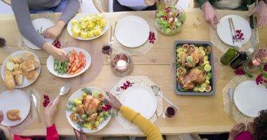 Çeşitli aileler akşam yemeğine başlıyor, yemek masasında kızarmış tavuk tabağı ve maşalı salata servis ediyorlar. Aile, akşam yemeği, toplantı, kutlama, neşe, mutfak, sosyal