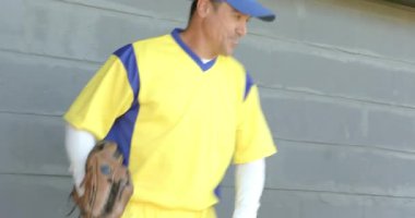 Oyuncu, yedek kulübesinde takım arkadaşlarına katılıyor eldiven hazırlama ekipmanlarını denetliyor. Sporcular, takım çalışması, yoldaşlık, açık hava, spor giyim, boş zaman, gündelik