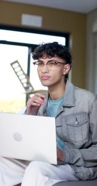 Dikey video: Gözlük takan erkek, bir sonraki girişin planlarını daktilo ediyor, duraklatıyor. Konsantrasyon, yenilik, çalışma alanı, modern, gündelik, üretkenlik, dikey video