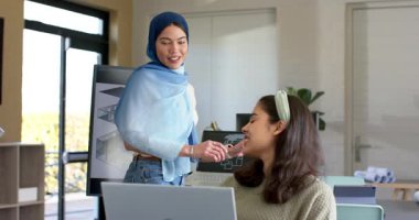 Muhtelif kadın iş arkadaşları ofiste 3D planlarını inceleyen dizüstü bilgisayarı selamlıyor ve işaret ediyor. İşbirliği, takım çalışması, profesyonel, modern, yenilik, ofis, iletişim