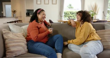 Çeşitli bayan arkadaşlar ellerinde telefonla oturma odasındaki gri kanepede hikayeler anlatıp gülüyorlar. Arkadaşlık, sohbet, rahatlık, sıcaklık, bağlantı, modern
