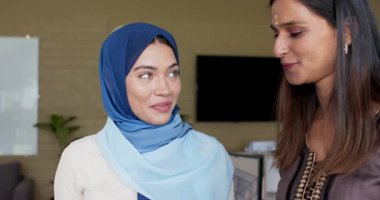 Hintli bayan meslektaşlar ofiste monitörle konuşuyor, omuz omuza verip morallerini yükseltiyorlar. İşbirliği, akıl hocalığı, destek, takım çalışması, çeşitlilik, güçlendirme, iletişim