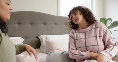 İki kız arkadaş sıcak bir şekilde gülüşüyor, sohbet ediyor ve yatak odasındaki büyük boy yatakta beşlik çakıyor. Arkadaşlık, samimiyet, bağlantı, rahatlama, konukseverlik, neşeli, gündelik