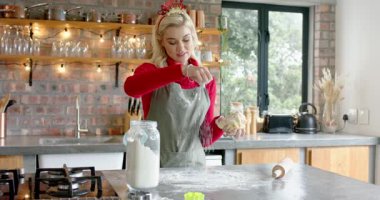 Yapışkan hamuru fark eden kadın mutfakta yemek pişiriyor un serpiyor sonra yoğuruyor ve yuvarlanmayı açıklıyor. Pişirme, aşçılık, yerli, kırsal, işçilik, aroma, farkındalık