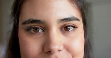 Yirmili yaşların başında, elinde bakışlarla gülümseyen, gülen, aydınlık odada başını eğen bir kadın. Empati, sıcaklık, özgünlük, güzellik, yüz ifadeleri, samimiyet, huzur.