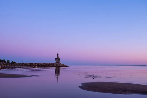 美丽的粉色日落 一艘经过教堂的船 站在湖岸或海滨的教堂 落日在水中的倒影 — 图库照片
