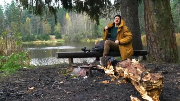 Man Sits Lake Bench Next Tree Photographer Lake Calm Reasoning — Stock Video