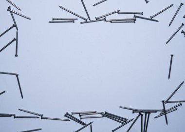 Beyaz arka planda düz tırnaklar vardı. Mesaj için çerçeve. İnşaat aletleri, inşaat teması. Mesaj atabileceğin bir yer. Hobnails ve pinler.