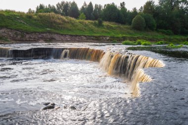 Şelale, nehirden akan su. Kahverengi renkli, fırtınalı bir nehir..