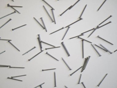 Beyaz arka planda düz tırnaklar vardı. Mesaj için çerçeve. İnşaat aletleri, inşaat teması. Mesaj atabileceğin bir yer. Hobnails ve pinler.