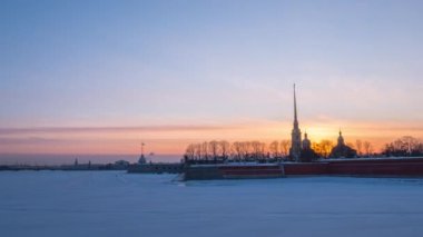 St. Petersburg 'daki Timelapse Petropavlovsk Kalesi. Neva Nehri 'ne ve tavşan adasına karşı gece gündüz değişiyor. Kışın Peter ve Paul Kalesi. 4K Buzda İnsanların Zaman Çizelgesi.