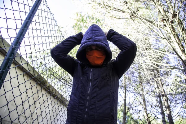 Young street gang with mask in park, social problem