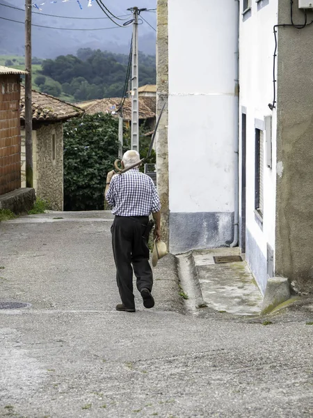 杖を持った老人が村を歩き — ストック写真