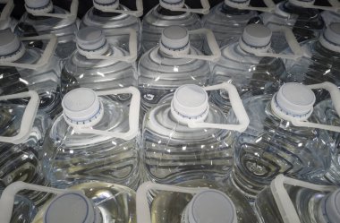 Süpermarkette bir şişe maden suyu, plastik kaplar, bahar