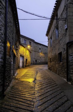 Aydınlatılmış sokak lambaları, inşaat ve mimarisi olan karanlık şehir sokağı.