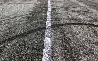 Kentsel caddede tekerlek izleri, araç kayması, doku.