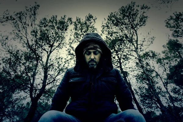 Şapkası ve maskesi, depresyonu ve yalnızlığı olan dalgın bir adam.
