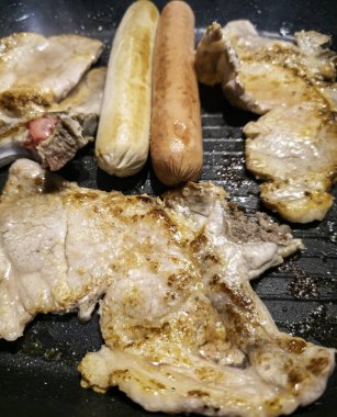 Izgarada ızgara kuzu pirzolası ve sosis.