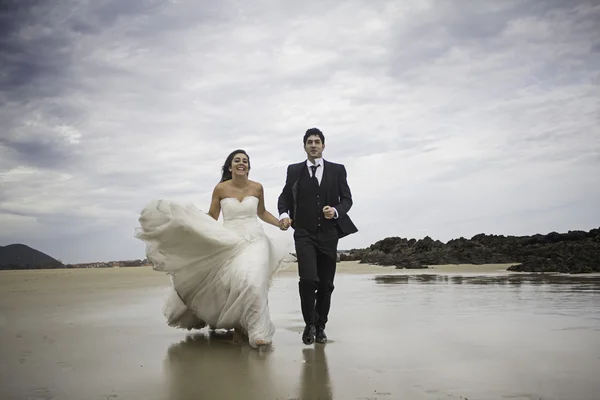 Grooms correndo praia — Fotografia de Stock