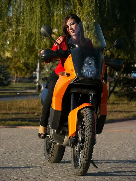 Schöne junge Brünette auf einem Motorrad. — Stockfoto