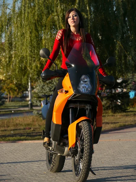 Schöne junge Brünette auf einem Motorrad. — Stockfoto