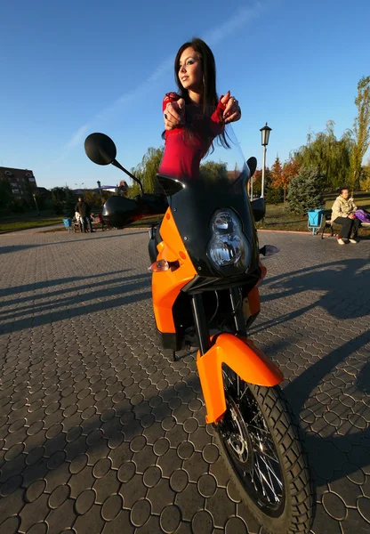 Schöne junge Brünette auf einem Motorrad. — Stockfoto