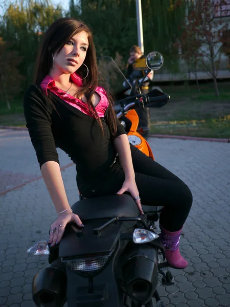 Beautiful young brunette on a motorcycle. — Stock Photo, Image