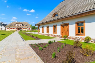 TOKARNIA VILLAGE, POLAND - 12 Mayıs 2016: Polonya 'nın Tokarnia köyündeki açık hava müzesindeki yeşil çayır üzerindeki geleneksel restoran binaları.
