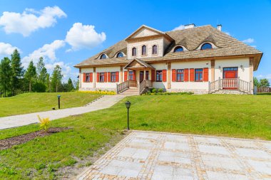 TOKARNIA VILLAGE, POLAND - 12 Mayıs 2016: Polonya 'nın Tokarnia köyündeki açık hava müzesinde yeşil çayır üzerindeki geleneksel restoran binası.
