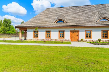 TOKARNIA VILLAGE, POLAND - 12 Mayıs 2016: Polonya 'nın Tokarnia köyündeki açık hava müzesinde yeşil çayır üzerindeki geleneksel restoran binası.