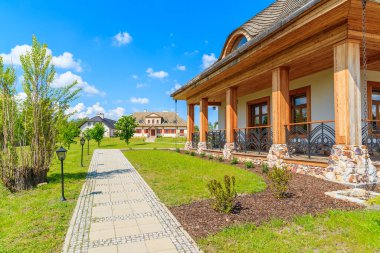 TOKARNIA VILLAGE, POLAND - 12 Mayıs 2016: Polonya 'nın Tokarnia köyündeki açık hava müzesindeki yeşil çayır üzerindeki geleneksel restoran binaları.