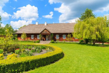 Eski geleneksel malikane ve Tokarnia köyündeki güzel bahçe güneşli bahar günü, Polonya