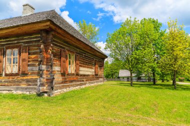 TOKARNIA VILLAGE, POLAND - 12 Mayıs 2016: Polonya 'nın Tokarnia köyündeki açık hava müzesinde yeşil çayır üzerindeki eski bir kır evi.