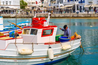 MYKONOS ISLAND, GREECE - 14 Mayıs 2016: Yunanistan 'ın Mykonos limanındaki bir balıkçı teknesinde çalışan balıkçı.
