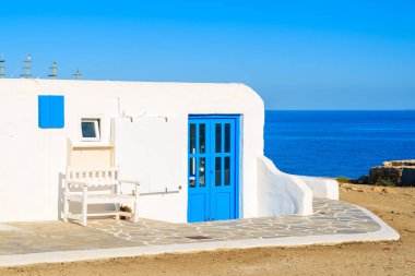 Yunanistan 'ın Mykonos adasında arka planda mavi deniz bulunan beyaz Yunan evi