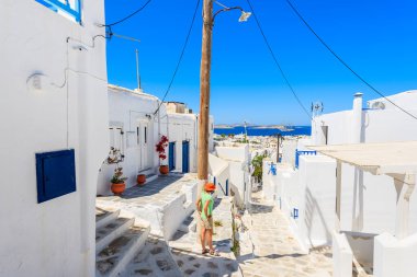 Mykonos şehir caddesinde duran genç bir kadın turist denize, Kiklad adalarına, Yunanistan 'a bakıyor