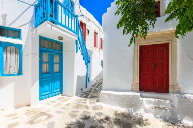Güzel Mykonos kasabası, Cyclades adaları, Yunanistan 'da mavi pencere ve kapılarla bembeyaz bir cadde manzarası
