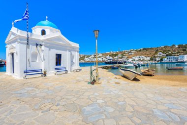 Yunanistan 'ın Cyclades adalarındaki Mykonos limanında mavi kubbeli tipik bir beyaz kilise.