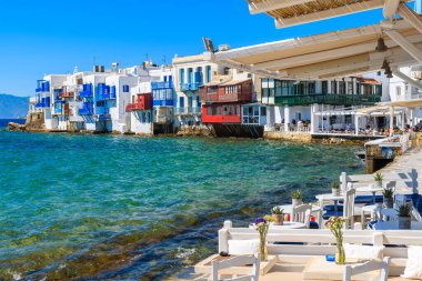 MYKONOS PORT, GREECE - 16 Mayıs 2016: Yunanistan 'ın Mykonos kentinin Little Venice bölgesindeki sahil şeridinde bir restoranın tabloları.