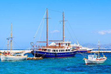 MYKONOS PORT, GREECE - 17 Mayıs 2016: Yunanistan 'ın Mykonos adasındaki Mykonos limanında mavi denizde yelkenli ve balıkçı tekneleri.