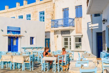 NAOUSSA TOWN, PAROS ISLAND - 17 Mayıs 2016: Yunanistan 'ın Paros adasındaki Naoussa limanındaki Yunan tavernasında akşam yemeği yiyen iki kadın.