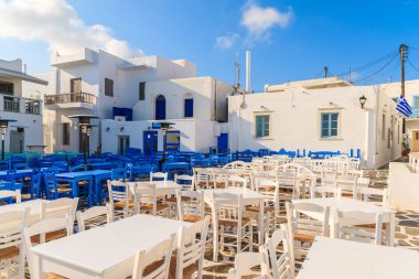 Yunanistan 'ın Paros adasındaki Naoussa limanındaki meydanda beyaz ve mavi meyhane masaları