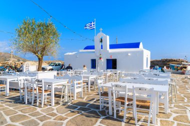 Yunanistan 'ın Paros Adası' ndaki Naoussa balıkçılık limanındaki tipik beyaz Yunan kilisesi ile meydandaki meydanlar