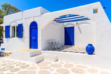 Yunanistan 'ın Paros adasındaki Naoussa köyünde mavi kapı ve pencereli tipik beyaz ev