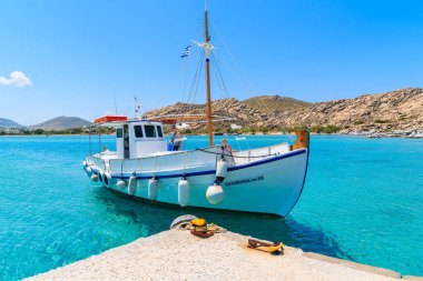 PAROS Adaları, GREECE - 20 Mayıs 2016: Yunanistan 'ın Paros Adası' ndaki Kolymbithres plajındaki rıhtıma giden iki turistle birlikte balıkçı teknesi.