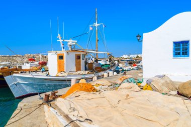 Yunanistan 'ın Paros adasındaki Naoussa limanındaki küçük bir kilisenin yanında demirleyen balıkçı teknesi.