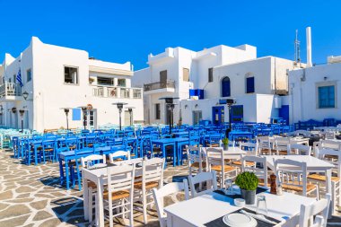 Yunanistan 'ın Paros adasındaki Naoussa limanındaki meydanda beyaz ve mavi meyhane masaları