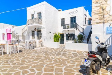 PAROS ISLAND, GREECE - 20 Mayıs 2016: Yunanistan 'ın Paros adasındaki Naoussa limanındaki bir Yunan restoranının önünde scooter parkı.