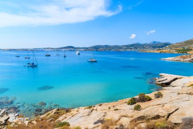 Yunanistan 'ın Paros adasındaki Monastiri körfezinde, gök mavisi denizde yüzen tekneler