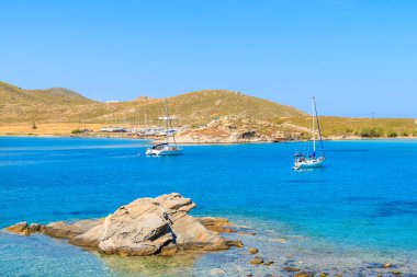 Yunanistan 'ın Paros adasındaki Monastiri Körfezi' nin masmavi deniz suyunda yüzen tekneler